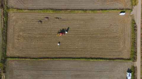 Top-Down Static Aerial Shot of Tractor Moving Hay Bales Stock Footage 345341391