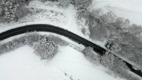 Top down static shot of car going through iced up curving road Stock Footage 225271333