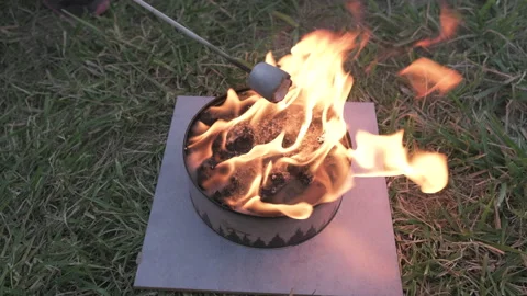 Top down static shot of marshmallow being roasted over portable fire pit Video stock 142833066