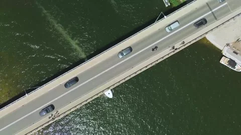 Top-Down Static Shot of Motorboat Passing Under Road Bridge with Cars Stock Footage 311728720