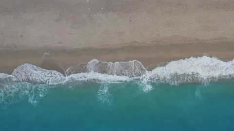 Top down static view of sandy beach and turquoise sea waves at shore edge Stock Footage 144844042