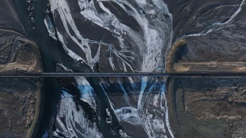 Top down steady shot at dusk of old Icelandic bridge, frozen river patterns 库存影片 333606666