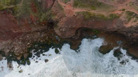 Top down steady view of big waves of Nazare crashing on cliffs in Portugal. Stock Footage 239577979