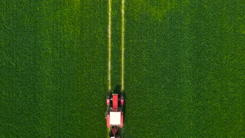 Top down still shot with tractor with sprayer moving in and out frame. Aerial Stock Footage 311932110