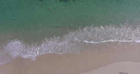 Top down of swimmer at the beach Aerial Stock Footage 250077244