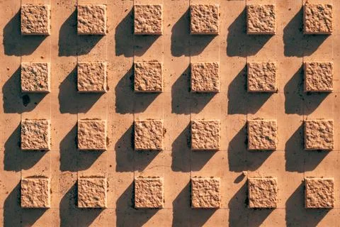 Top-down texture of tactile paving tiles with raised square studs casting s.. Stock Photos