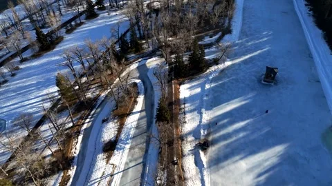 Top Down then push forward cinematic Aerial View of Frozen Bowness Park Calgary Видео 336354922