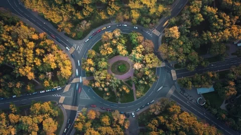 Top down time-lapse aerial view of a park with a roundabout intersection Stock Footage 276385332