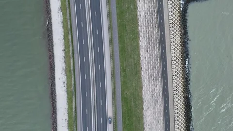 Top down tracking over roadway bike path and sea wall Stock Footage 331828970