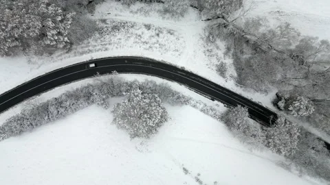 Top down tracking shot of car speeding through iced up curve in snow and ice Stock Footage 225271172