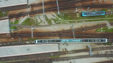 Top-down tracking shot of modern electric train entering railway station Stock Footage 311000695