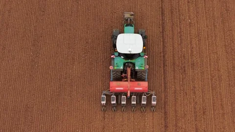 Top down tractor with seed drill sowing agricultural crops in textured plowed Stock Footage 335683241