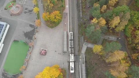 Top Down Tram Train Departing Tram Stop, Autumn Foliage Scene, Aerial Stock Footage 143663576
