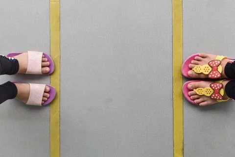 Top down of two people keep spaces between each in line on flooring. Stock Photos
