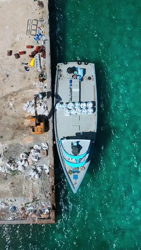 Top down vertical aerial view of boat with cargo moored at tropical island pier Vídeos de archivo 346270948