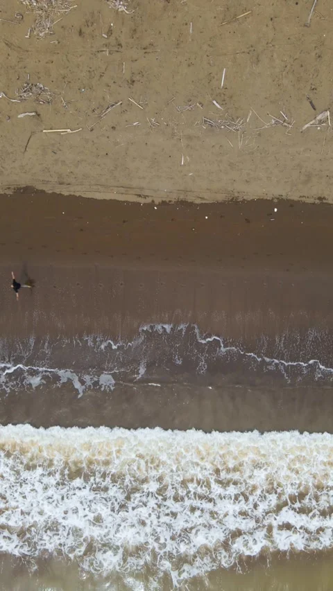 Top Down Vertical Drone View of Man Running on Beach at Sunset Stock Footage 326332483