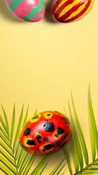 A top-down vertical shot featuring vibrant, hand-painted Easter eggs with u.. Stock Photos
