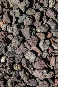 Top-down vertical view of dark porous lava rock gravel. Volcanic stone texture Stock Photos