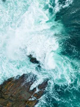 Top-Down Vertical View of Turquoise Ocean Waves Crashing on Coastal Rocks Stock Photos