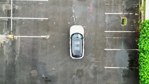 Top down video white mini cooper driving alone. Empty airport parking. Video stock 244447269