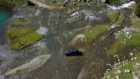 Top down view of 4x4 off-road car parked by shallow mountain river 库存影片 334326976
