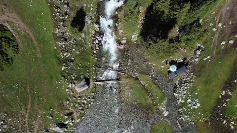 Top down view of 4x4 off-road car and campsite by rushing mountain stream Видео 334327016