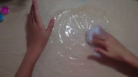 Top Down View of Activating Clear PVA Glue Mixture on Wooden Desk for Homemade Stock Footage 342336420