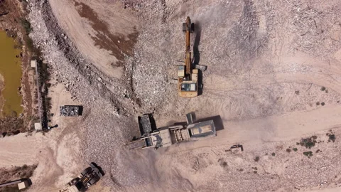 Top-down view of an active landfill or demolition site with excavator loading Vídeos de archivo 342478696