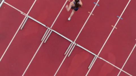 Top down view aerial drone shot of a professional female athlete sprinting on a Stock Footage 309111971