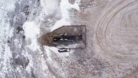 Top down view and ascending from a drone of an oil pumpjack in motion. Stock Footage 233615310