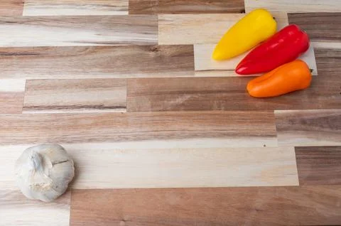 Top-down view of assorted fresh vegetables arranged on a striped wooden cutti Stock Photos