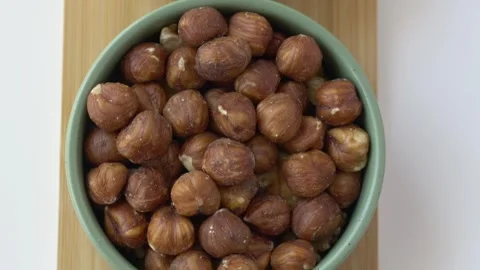 Top down view of assorted nuts arranged in bowls. Footage emphasizes natural Stock Footage 345653485