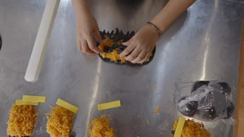 Top down view of a baker hands skillfully assembling a charcoal bread roll, Stock Footage 328983885