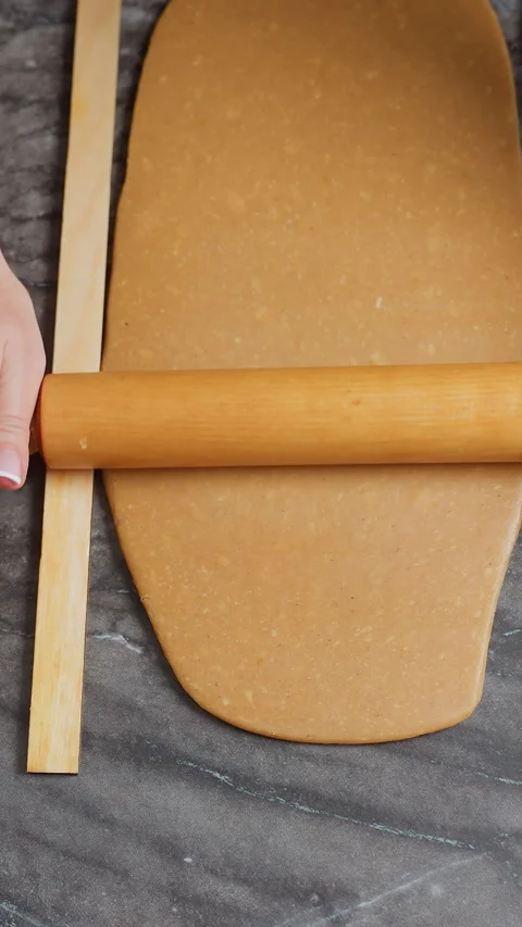 Top-Down View of Baker Rolling Dough with Wooden Rolling Pin Stock Footage 320373956