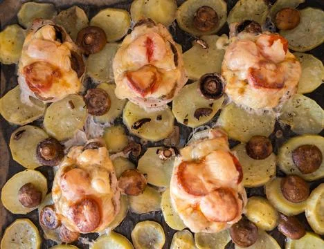 A top-down view of a baking tray filled with French-style pork, potatoes Stock Photos