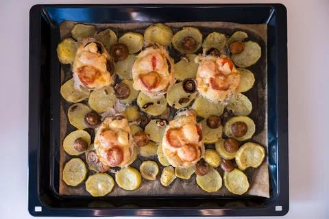 A top-down view of a baking tray filled with French-style pork, potatoes Stock Photos