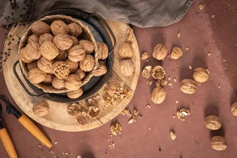 Top-down view of a basket brimming with whole walnuts on a wooden board nex.. Stock Photos