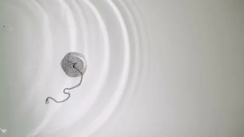 Top-down view of bathtub filled with water. Drops from tap fall into water and Stock Footage 167616080