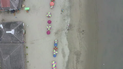 Top down view of a beach with colorful parasols and children playing Stock Footage 169903865