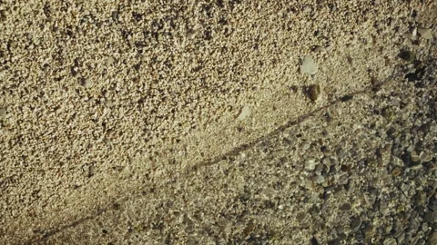 Top-down view of beach small pebbles being washed by a sea wave Stock Footage 313731275
