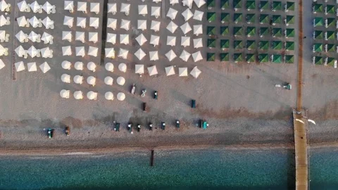 Top down view of a beach with tourists sunbeds and umbrellas with sand beach and Stock Footage 158576774