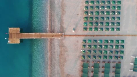Top down view of a beach with tourists sunbeds and umbrellas with sand beach and Stock Footage 158704448