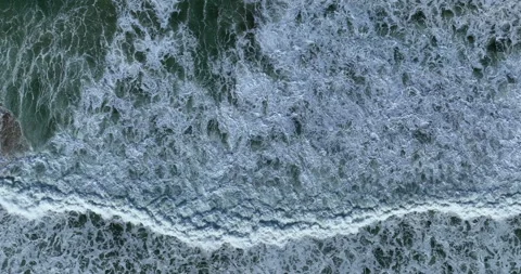 Top down view of big ocean waves rolling from above. Huge swell hitting Stock Footage 221084043