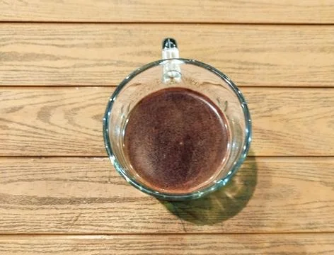 Top down view of black coffee or hot chocolate in a glass cup on wooden table Stock Photos