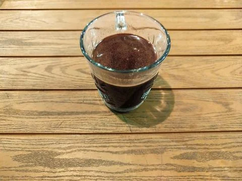 Top down view of black coffee in a glass cup on wooden table Stock Photos