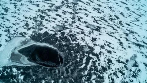 Top Down View of Black Ice Hole and Slush Textures on Frozen Winter Lake Stock Photos