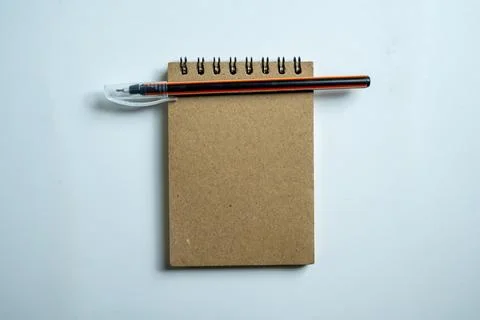 A top-down view of a blank brown spiral-bound notepad with an orange and bl.. 스톡 사진