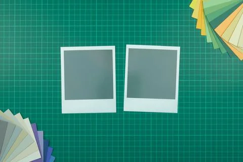 Top down view of blank instant film style photographs on cutting mat with col Stock Photos