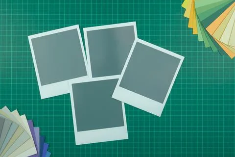 Top down view of blank instant film style photographs on cutting mat with col Fotos de archivo