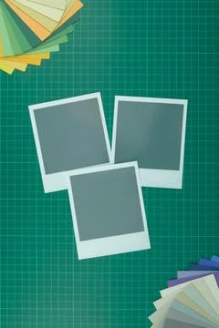 Top down view of blank instant film style photographs on cutting mat with col Fotos de archivo
